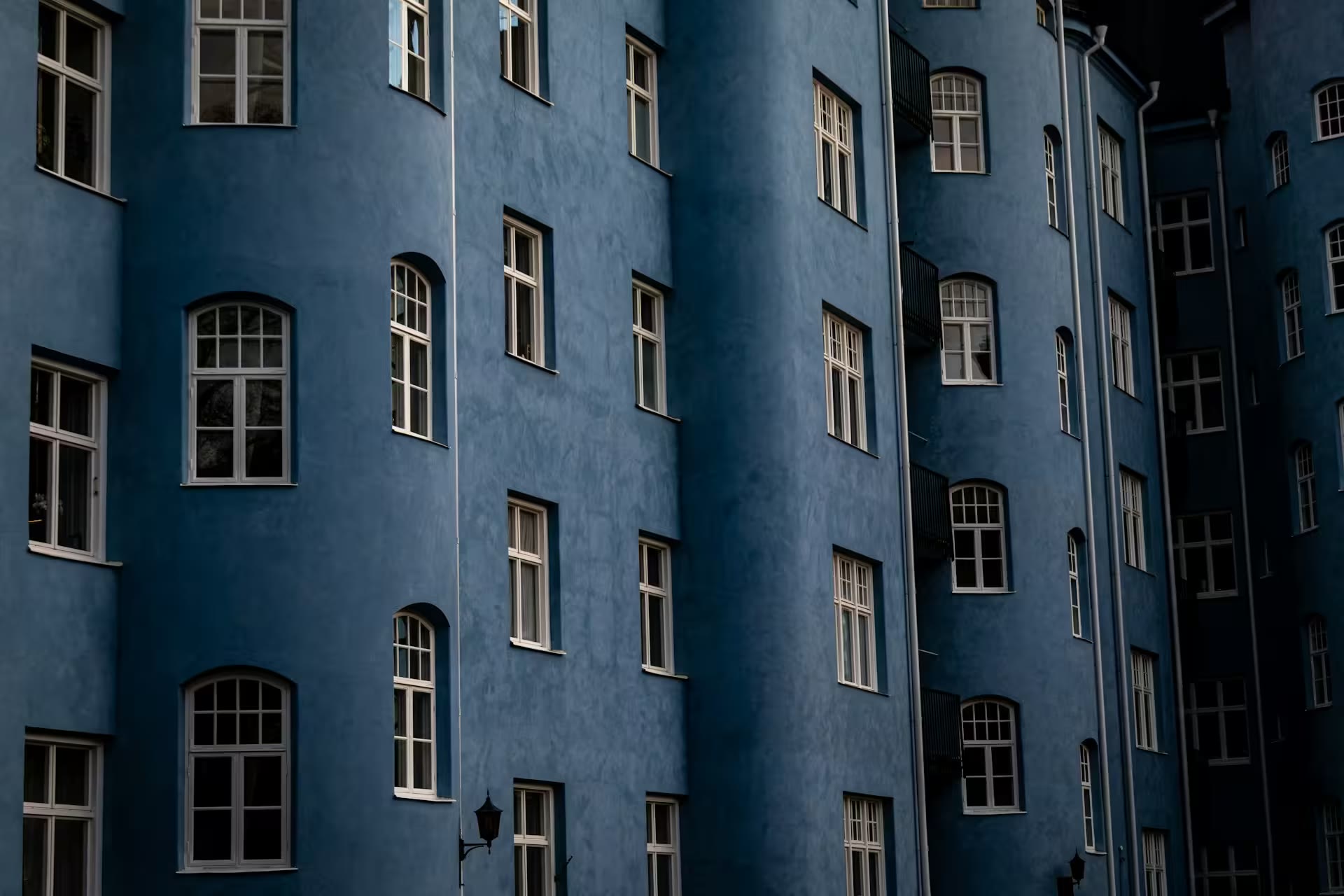 Blått flerbostadshus med spröjsade fönster